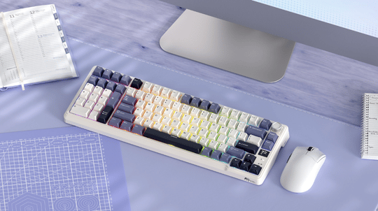 Mechanical keyboard on a desk with a computer monitor and mouse