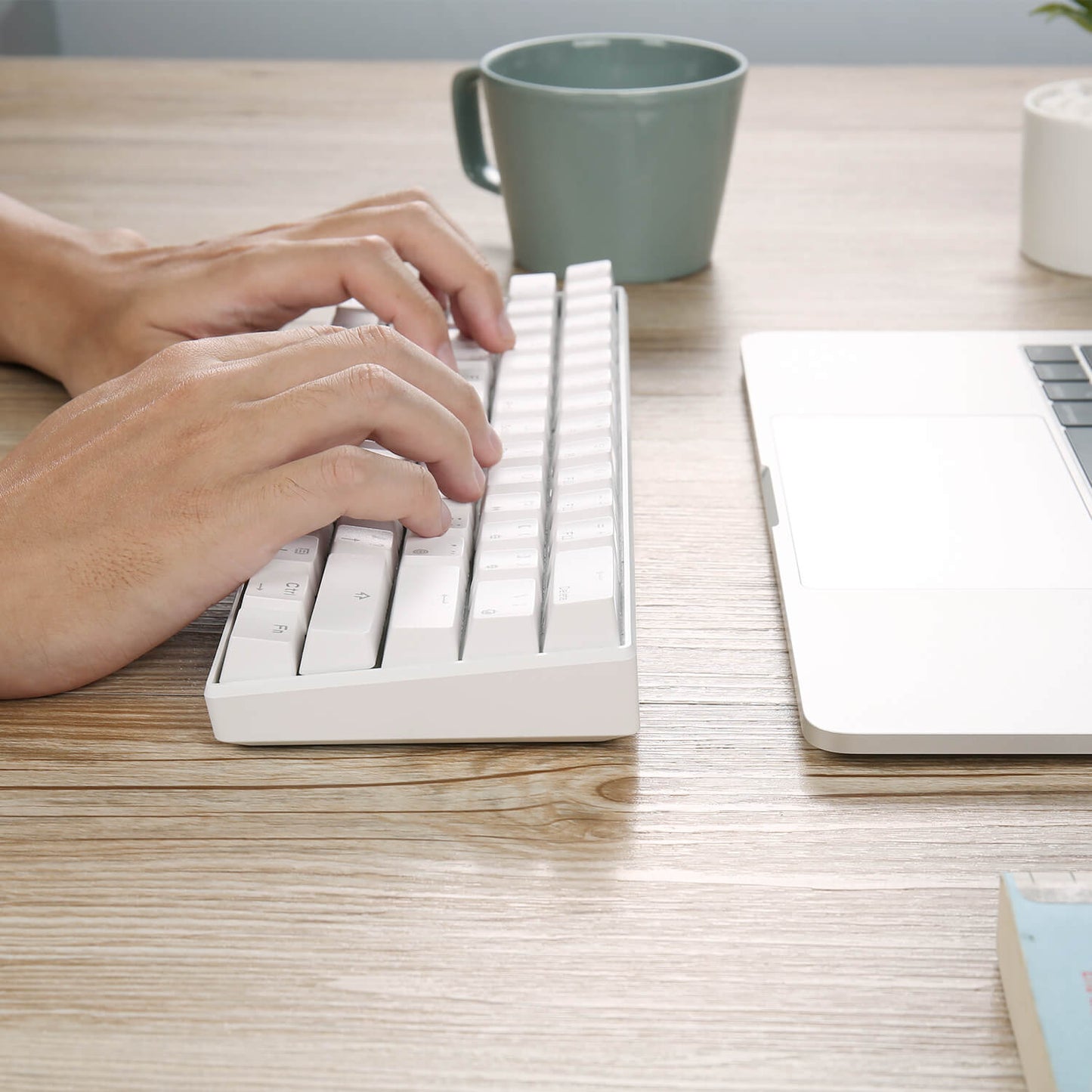 Person typing on the Royal Kludge RK61 white keyboard,  showcasing its ergonomic design and 60% compact layout