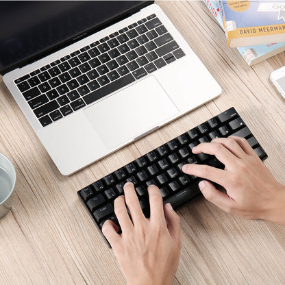 Person typing on the Black Royal Kludge RK61 white keyboard,  showcasing its ergonomic design and 60% compact layout